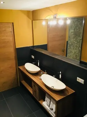 a bathroom with two sinks and a large mirror at Franzn Apartments in Petersberg