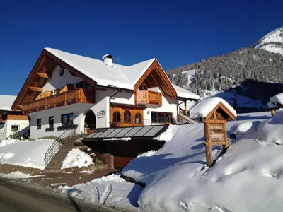 a house covered in snow with a sign in front at Chalet Romy - AP Sasplat in Pramauron