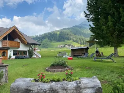 a person sitting on a bench in a yard at Chalet Romy - AP Sasplat in Pramauron