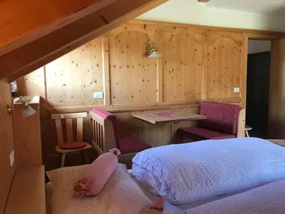 a bedroom with a bed and a table and chairs at Chalet Romy - AP Sasplat in Pramauron