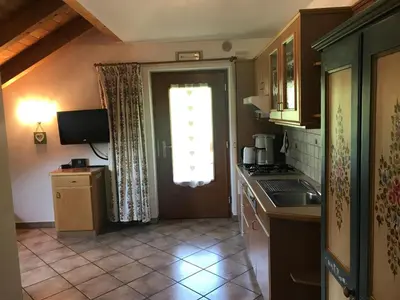 a kitchen with a sink and a door with a window at Chalet Romy - AP Sasplat in Pramauron
