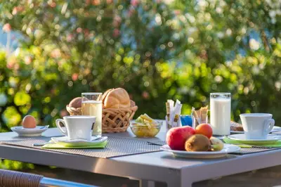 a table with a breakfast of eggs and fruit on it at Garni Hotel Ritterhof in Termeno