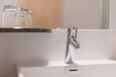 a sink with a faucet in a bathroom at Garni Hotel Ritterhof in Termeno