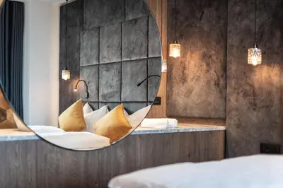 a room with a couch with a mirror at Hotel Goldene Traube in Termeno