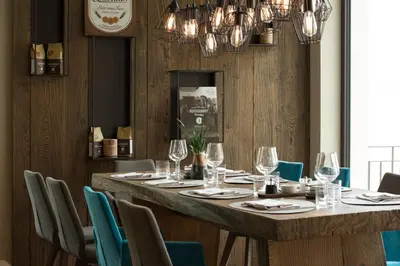 a long table in a restaurant with blue chairs at Hotel Goldene Traube in Termeno