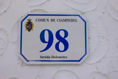 a blue and white sign on a wall at Cësa Valeria e Cësa Giulio in Campitello di Fassa