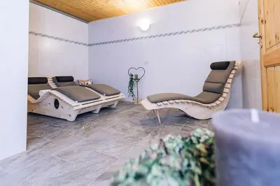two beds in a room with two chairs at Hotel Schönwies in Trodena