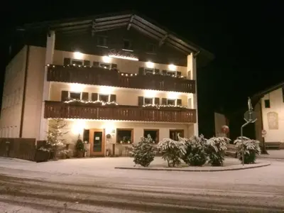 a building with snow on the ground in front of it at Hotel Schönwies in Trodena