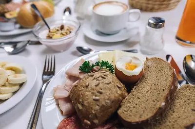 a plate of breakfast food with an egg and bread at Hotel Schönwies in Trodena