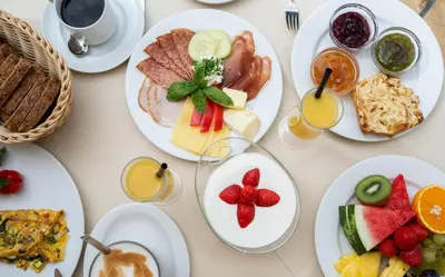a table with plates of food on it at Hotel Spitaler in Appiano sulla Strada del Vino