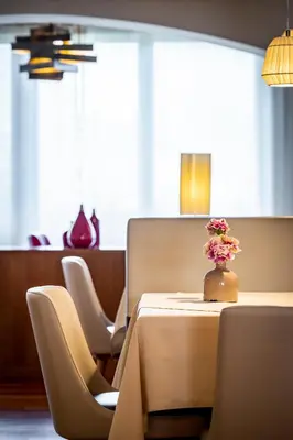 a table with a vase of flowers on it at Hotel Spitaler in Appiano sulla Strada del Vino