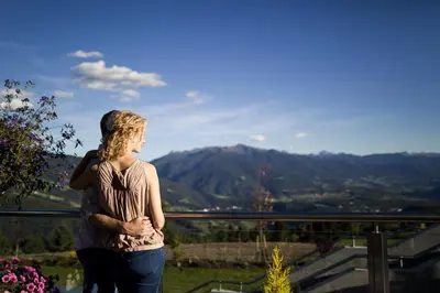 a woman standing on a hill looking at the mountains at Family Home Alpenhof in Maranza