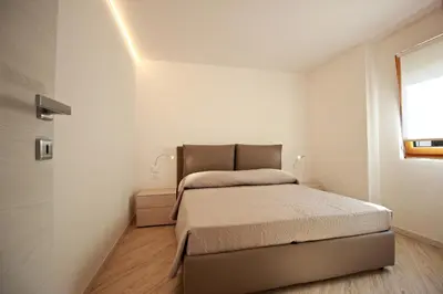 a small bedroom with a bed and a window at casa waldner in Castello di Fiemme