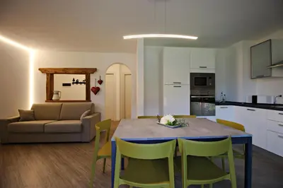 a kitchen and living room with a table and chairs at casa waldner in Castello di Fiemme