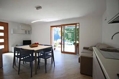 a kitchen and living room with a table and chairs at casa waldner in Castello di Fiemme