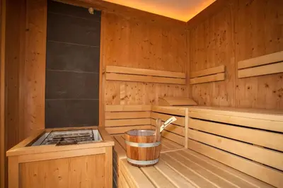 a wooden sauna with a trash can in it at Hotel Am Wolfgrubenersee in Soprabolzano