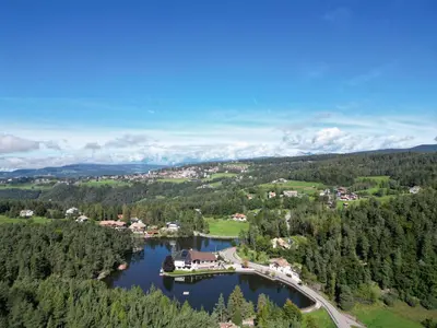 an aerial view of a bridge over a lake at Hotel Am Wolfgrubenersee in Soprabolzano