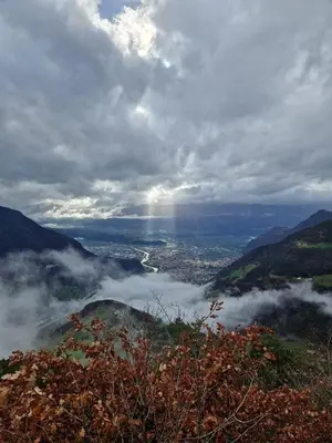 a view of a city in the clouds from a mountain at Hotel Am Wolfgrubenersee in Soprabolzano