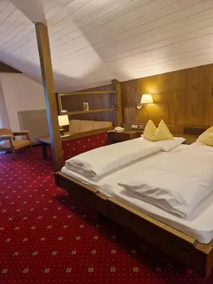 a hotel room with a large bed in a room at Hotel Am Wolfgrubenersee in Soprabolzano