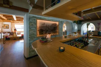 a kitchen with a bar with a bunch of wine bottles at Hotel Alpenfrieden in Maranza