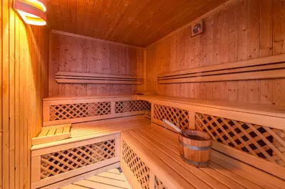 a wooden sauna with a bucket in the middle at Hotel Alpenfrieden in Maranza