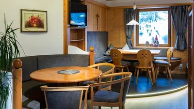 a living room with a table and chairs and a couch at Hotel Alpenfrieden in Maranza