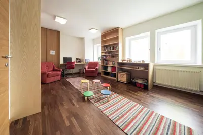 a living room with chairs and a rug at Hotel Masatsch in Caldaro