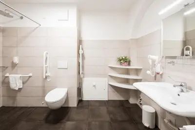 a white bathroom with a sink and a toilet at Hotel Masatsch in Caldaro