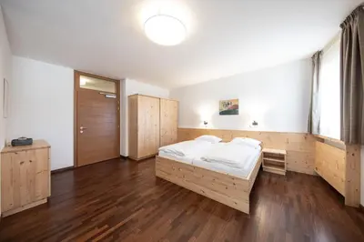 a bedroom with a large bed and wooden cabinets at Hotel Masatsch in Caldaro
