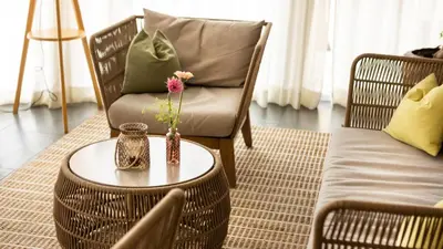 a living room with a chair and a table with a vase on it at Hotel Villa Laurus in Merano