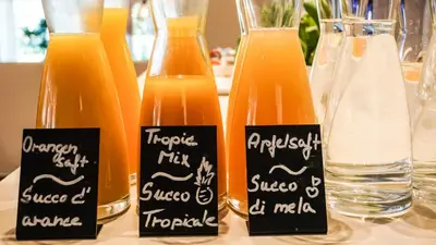 a group of bottles of orange juice on a table at Hotel Villa Laurus in Merano
