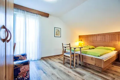 a bedroom with a bed and a table at Gasthof Anny in Marlengo