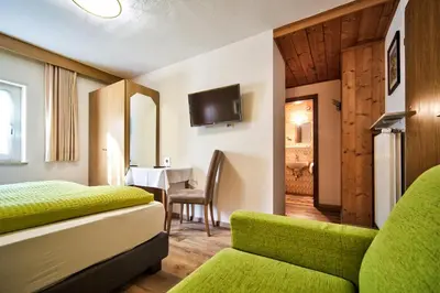 a hotel room with a bed and a couch and a table at Gasthof Anny in Marlengo