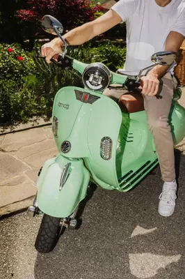 a woman is sitting on a green scooter at Thalguter - Rooms & Breakfast in Lagundo