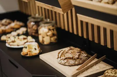a table with bread and other pastries on it at Thalguter - Rooms & Breakfast in Lagundo