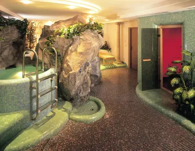 a bathroom with a large rock and a bath tub at Hotel Klotz in San Leonardo in Passiria