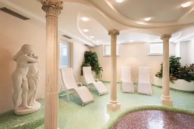 a room with a statue and chairs in it at Hotel Klotz in San Leonardo in Passiria