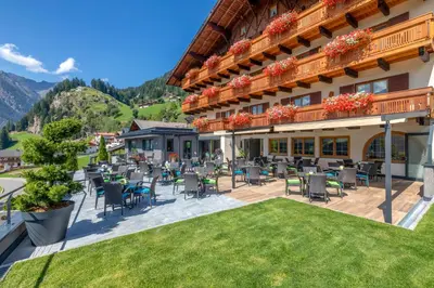 a hotel with a patio with chairs and tables at Hotel Kronhof in Moso
