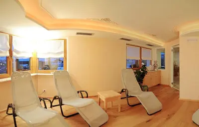 a room with chairs and a table and windows at Residence Rautal B&B ***S in San Vigilio Di Marebbe