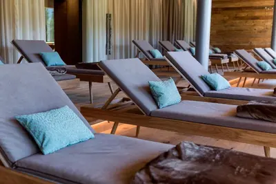 a row of chairs with blue pillows in a room at Hotel Gran Paradiso in San Cassiano
