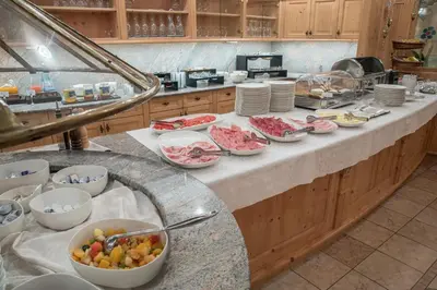 a kitchen with many bowls of food on a counter at Hotel Gran Paradiso in San Cassiano