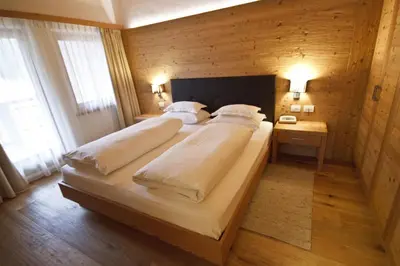 a bedroom with two beds in a wooden room at Hotel Gran Paradiso in San Cassiano