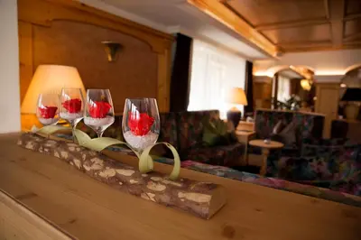 three wine glasses sitting on a counter in a room at Hotel Gran Paradiso in San Cassiano