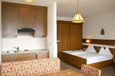 a hotel room with a bed and a kitchen at Panoramapension Etschblick in Meltina