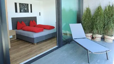 a room with a couch with red pillows and a chair at Residence Moritz in Avelengo