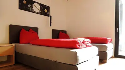 a room with two beds with red pillows on them at Residence Moritz in Avelengo