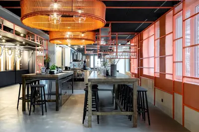 a kitchen with two tables and a bar with stools at Hotel Traminerhof in Termeno
