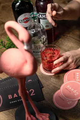a fake pink flamingo standing on a table with a drink at Hotel Traminerhof in Termeno
