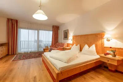 a bedroom with a large bed and a couch at Steinegger Eppan in Appiano sulla Strada del Vino