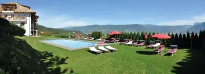 a group of chairs and umbrellas next to a pool at Steinegger Eppan in Appiano sulla Strada del Vino